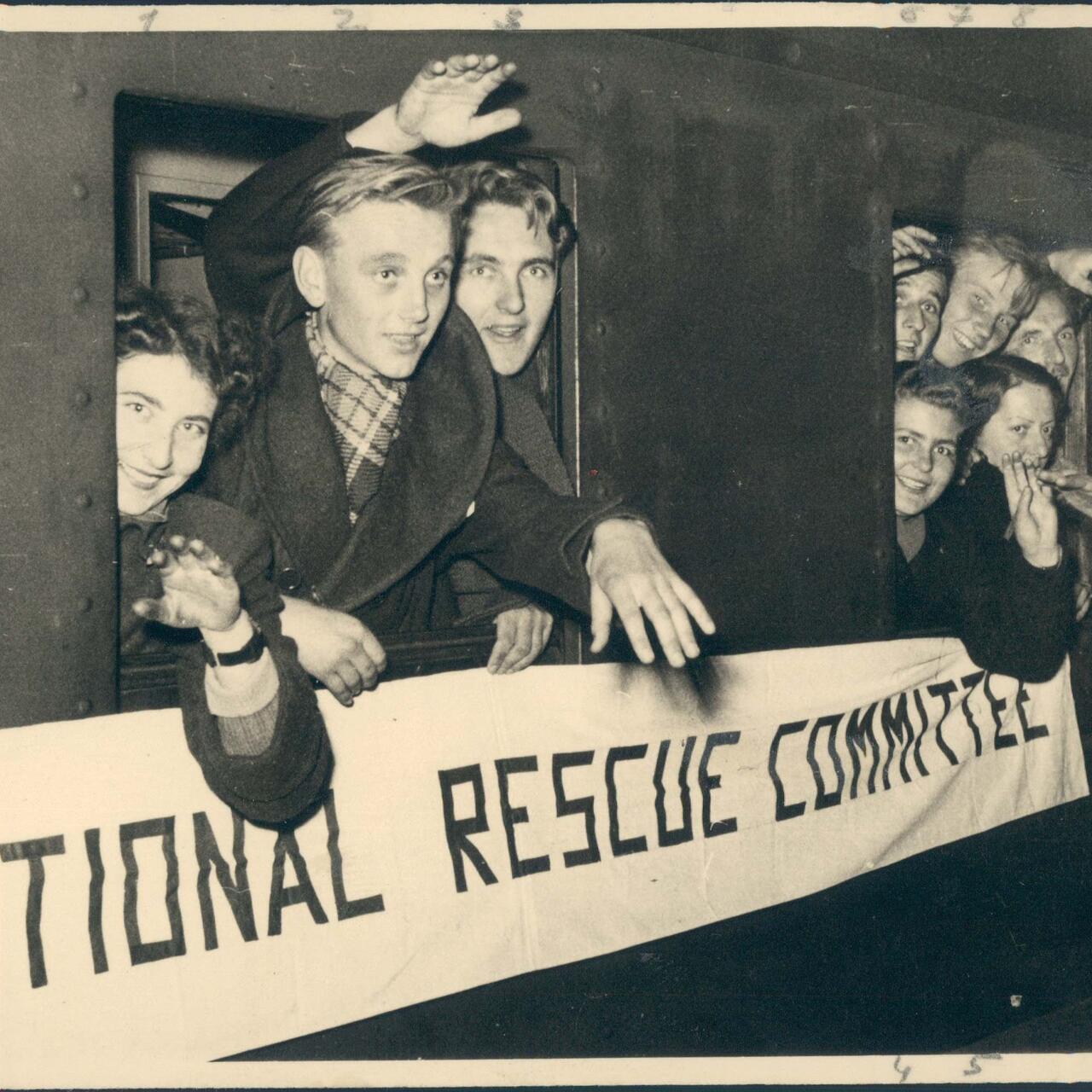 Mehrere Menschen schauen aus einem Zug