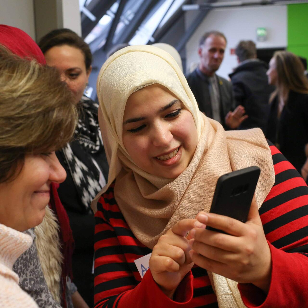Zwei Frauen schauen in ein Handy.