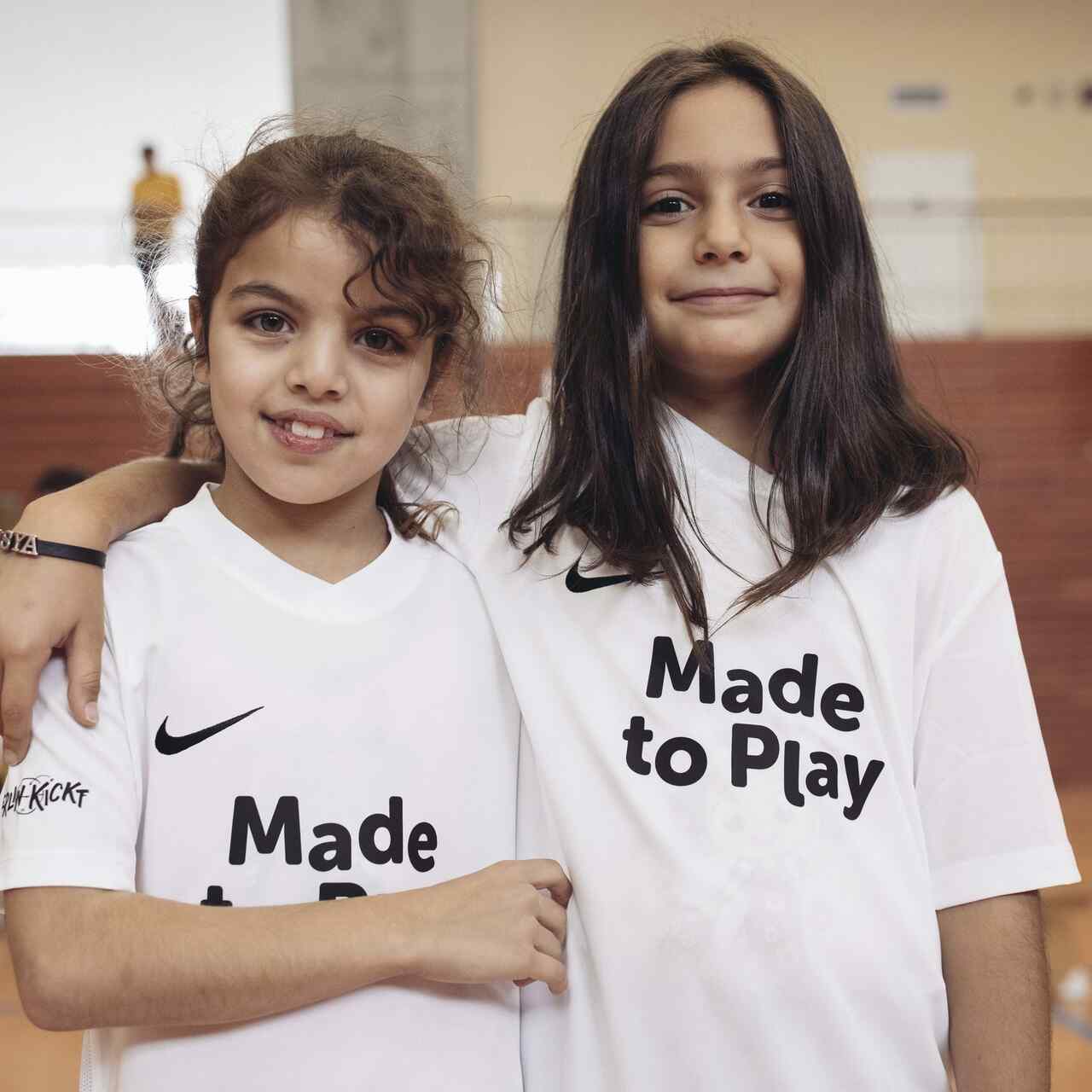 Zwei Mädchen stehen nebeneinander in einer Sporthalle