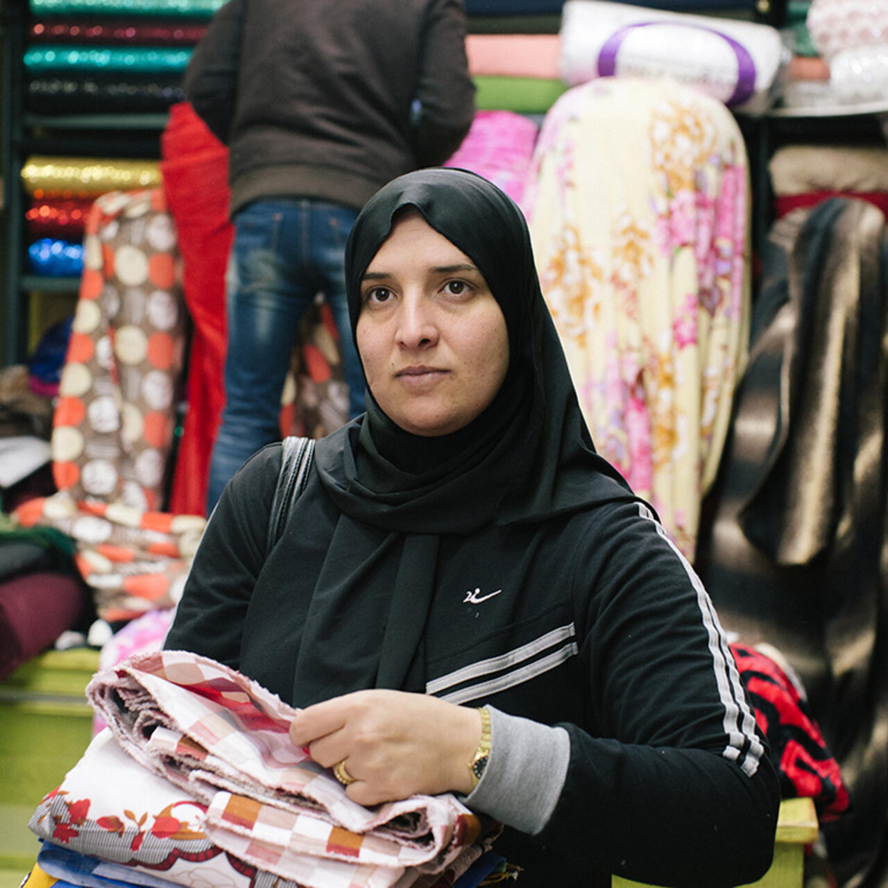 Rehab kauft Stoff auf dem Markt in Amman, Jordanien, ein.