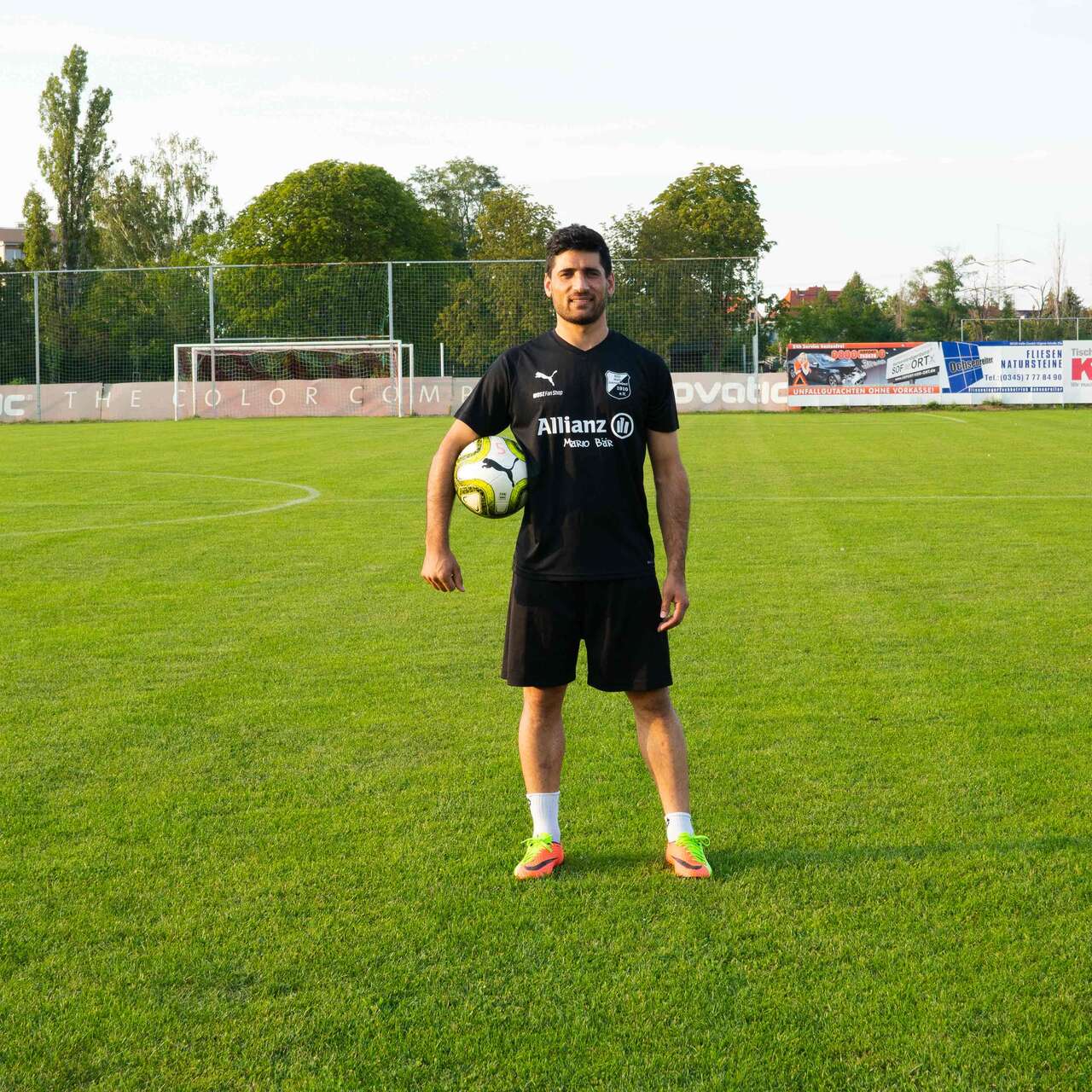 Mann steht und hält Fußball