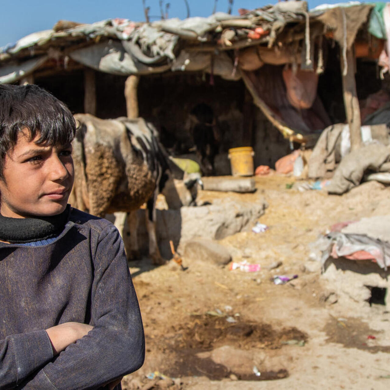 Ein Junge steht vor einen Zeltlager.