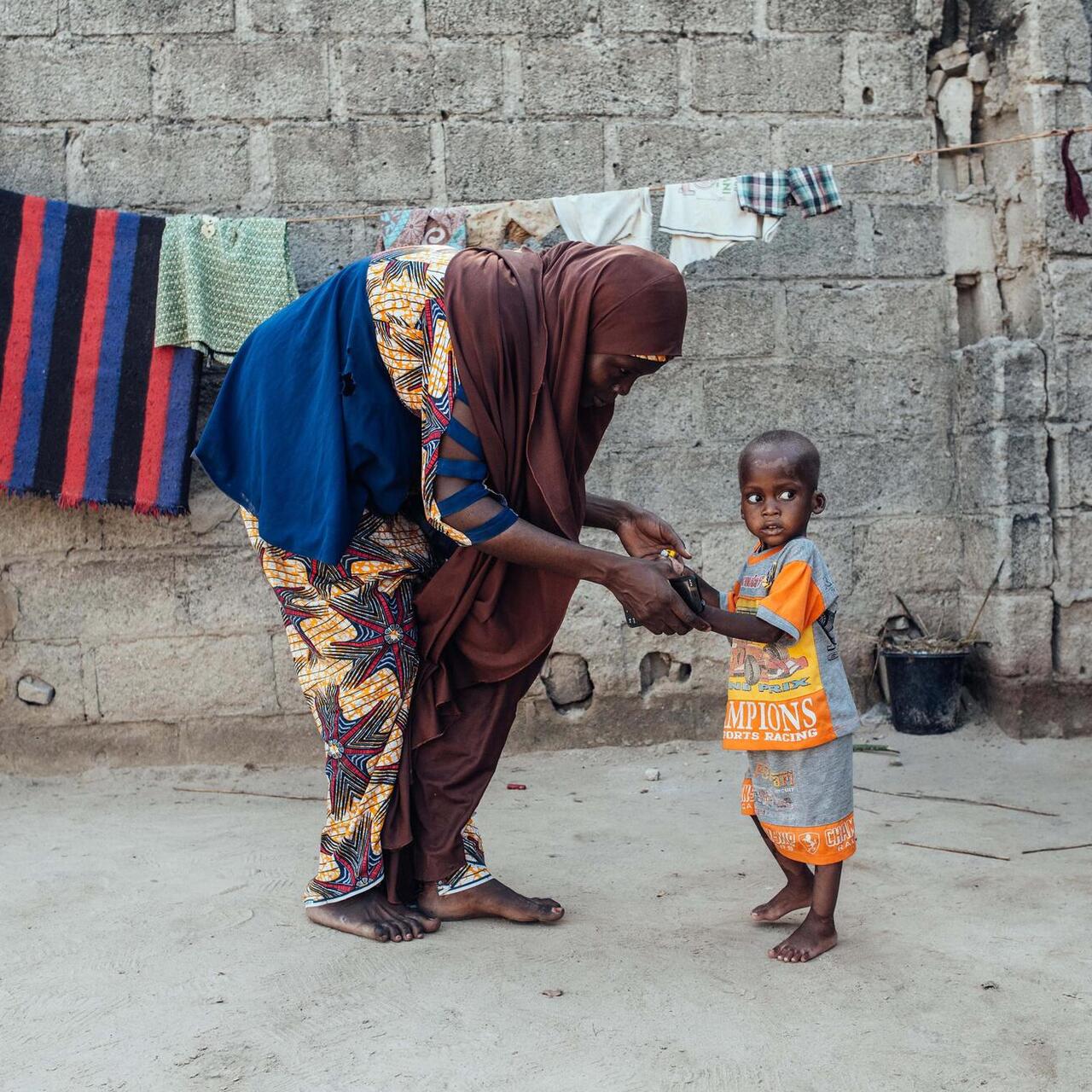 Naima och hennes barn Hadi övar på att gå utanför deras hus i Nigeria