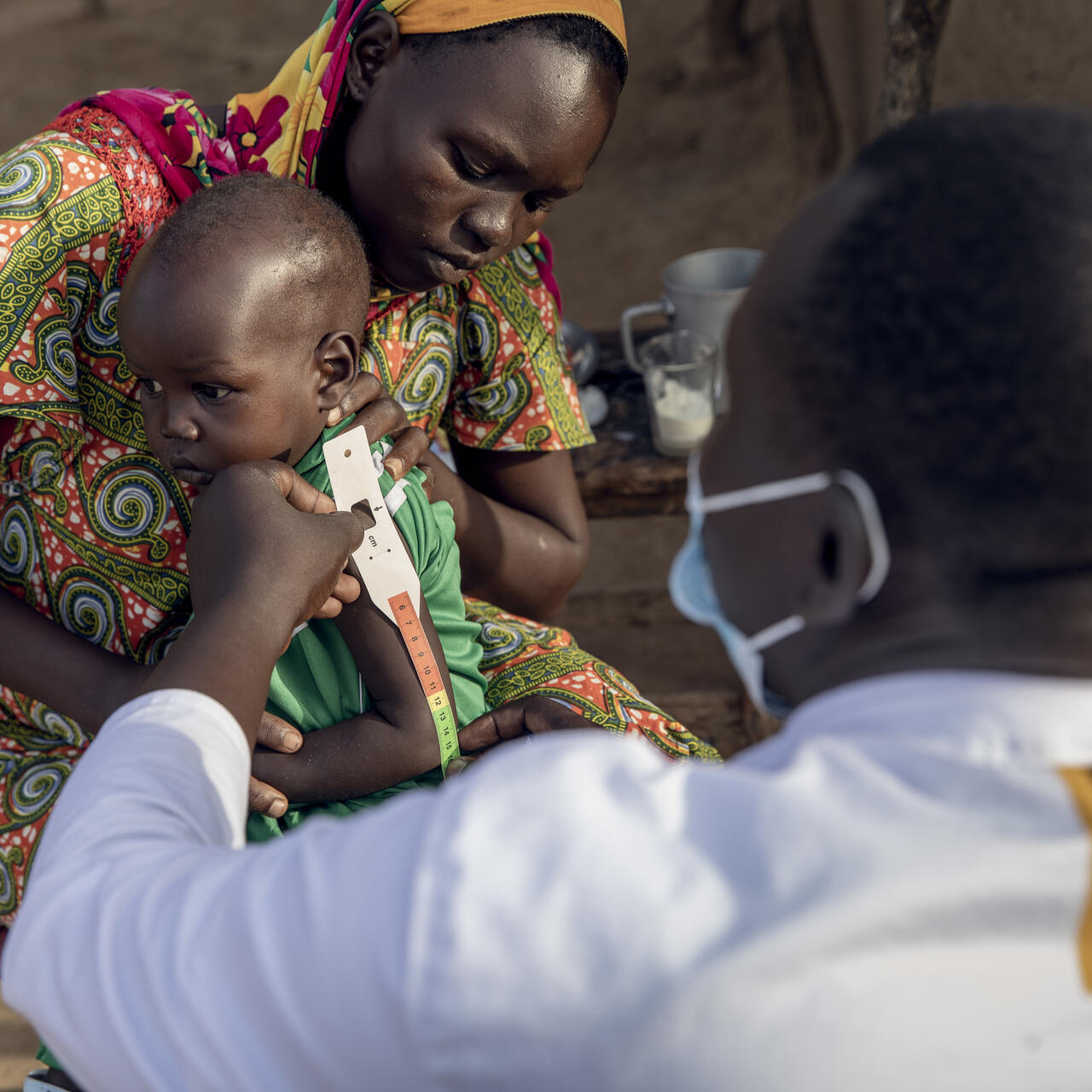 An IRC healthcare provider checks a baby for malnutrition in South Sudan