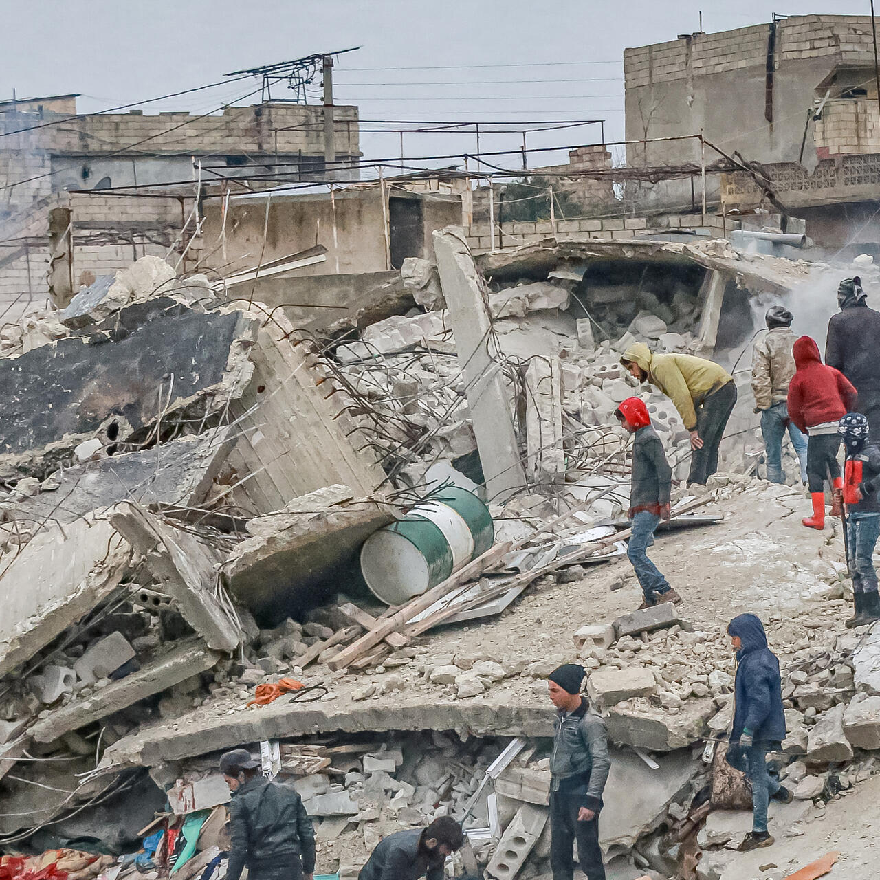 A crowd of medical personnel and civilians conduct search and rescue operations in the remains of destroyed buildings in Syria after the 7.7 earthquake on the morning of February 6, 2023.