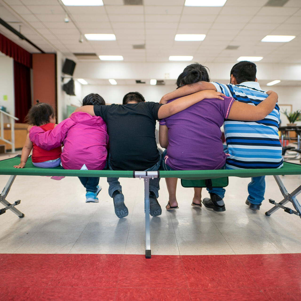 Marta, Julio and their children sit with their backs to the camera.