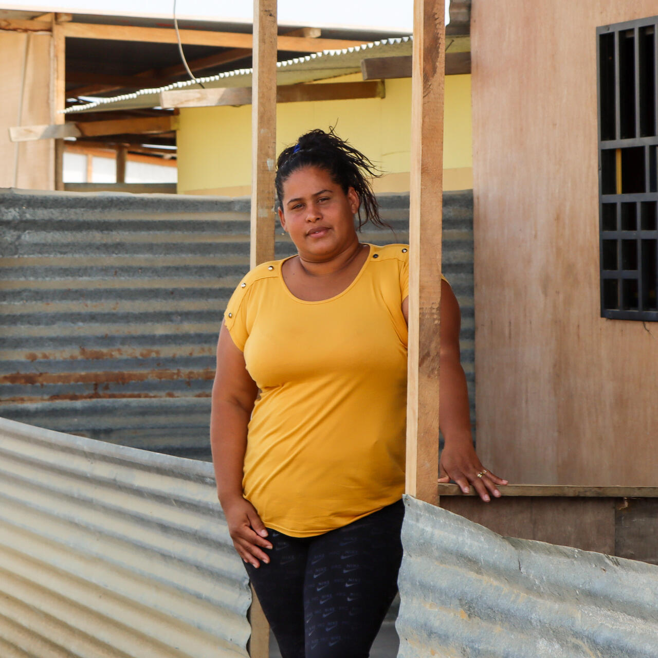Scarlett, a client of the IRC, poses for a photo outside of a house.