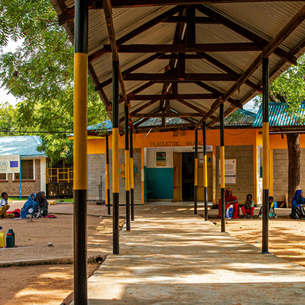 Outside the female ward at the IRC’s Hagadera Refugee Camp Hospital, Kenya (part of the Dadaab complex). Families of patients walk out during visiting hours.