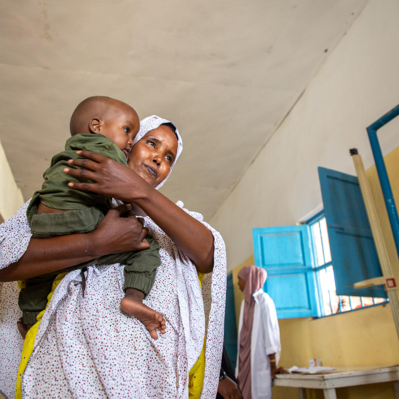 A mother holds her child close as the two walk through a malnutrition treatment ward in the Hanano Hospital in Somalia.