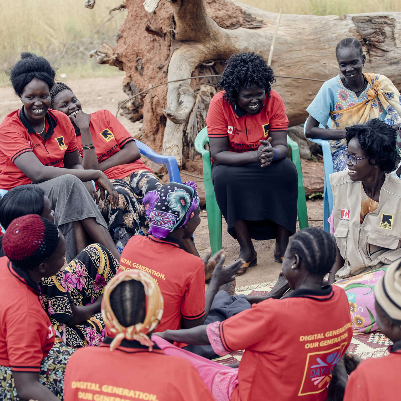 Kvinnor och flickor sitter i en ring och pratar med en medarbetare på RESCUE.