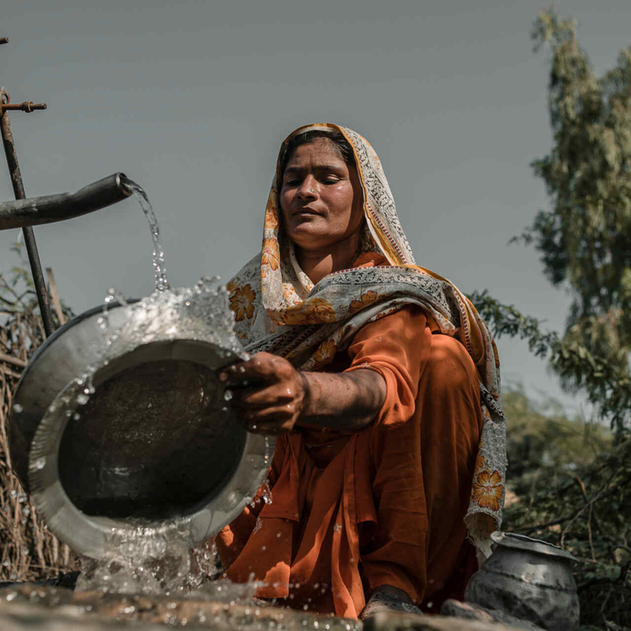 Rent vatten är viktigt - en kvinna i Pakistan diskar vid en vattenbrunn efter översvämningarna 2022.