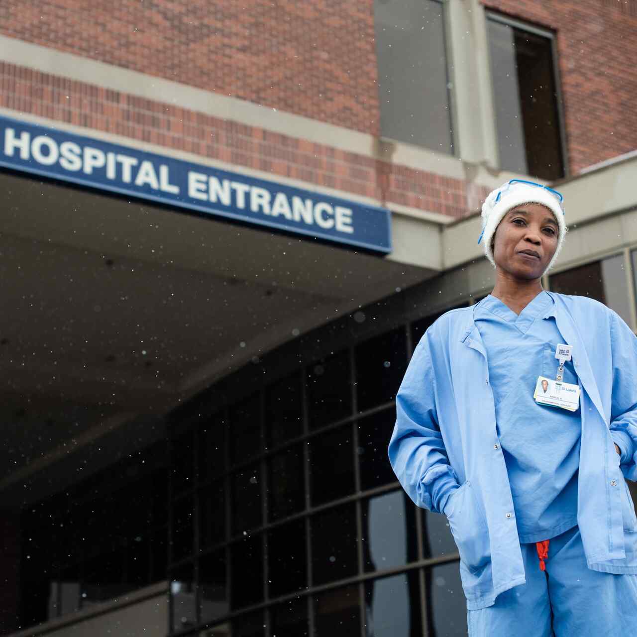Nabila, an environmental service technician and refugee, in front of the hospital where she works