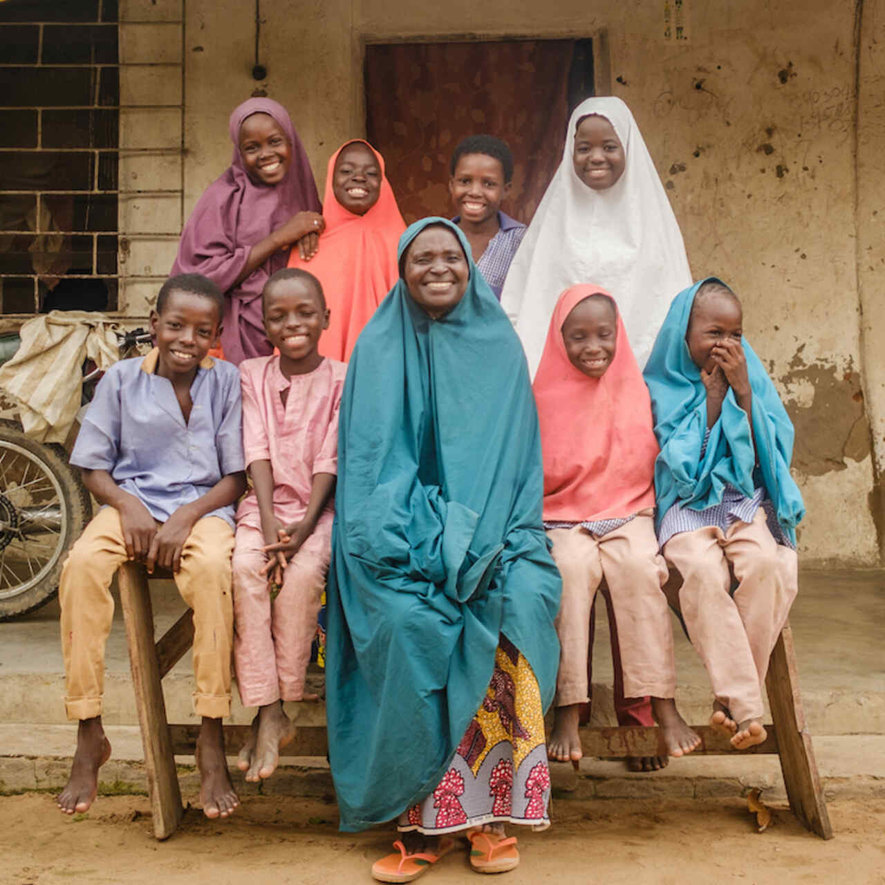 가족들이 집앞에 모여 환하게 웃고 있습니다.