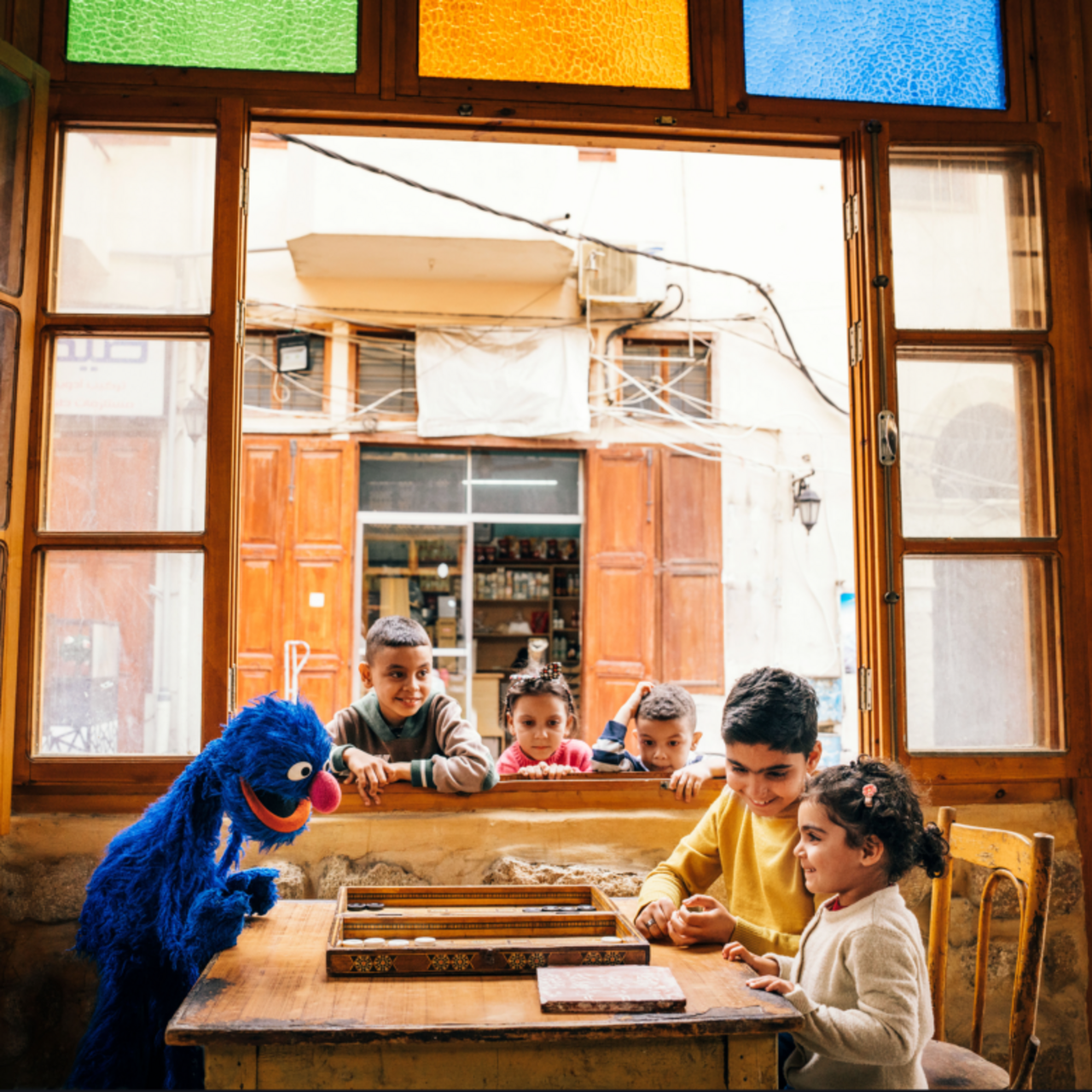 Promotional picture for Ahlan Simsim of Sesame Street character playing with children