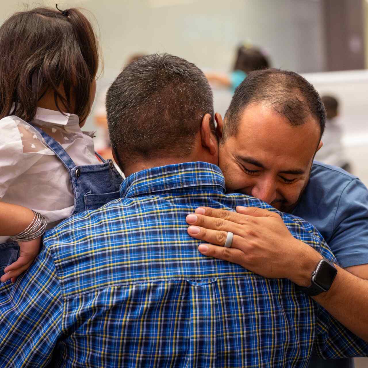 Pedro Moncada, an IRC immigration legal representative, embraces Mr. Husseini after his family was reunited.