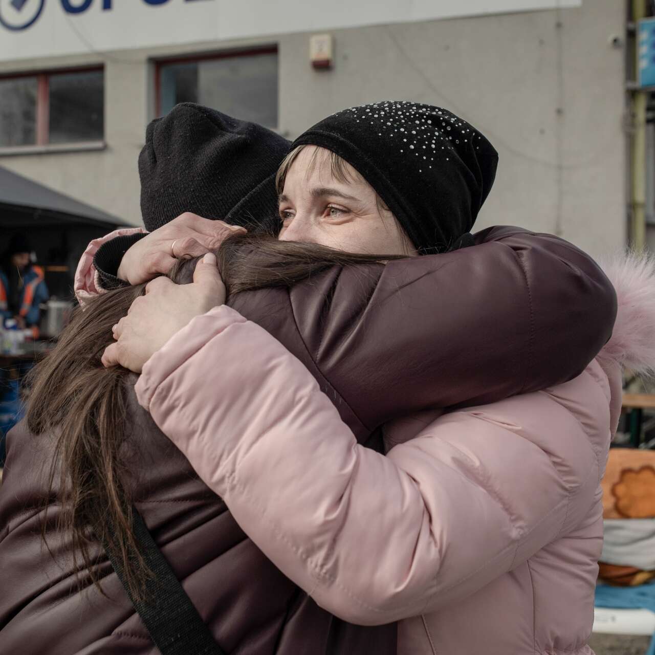 En mamma och hennes vuxna dotter kramas vid gränsövergången vid den Ukrainsk-Polska gränsen.