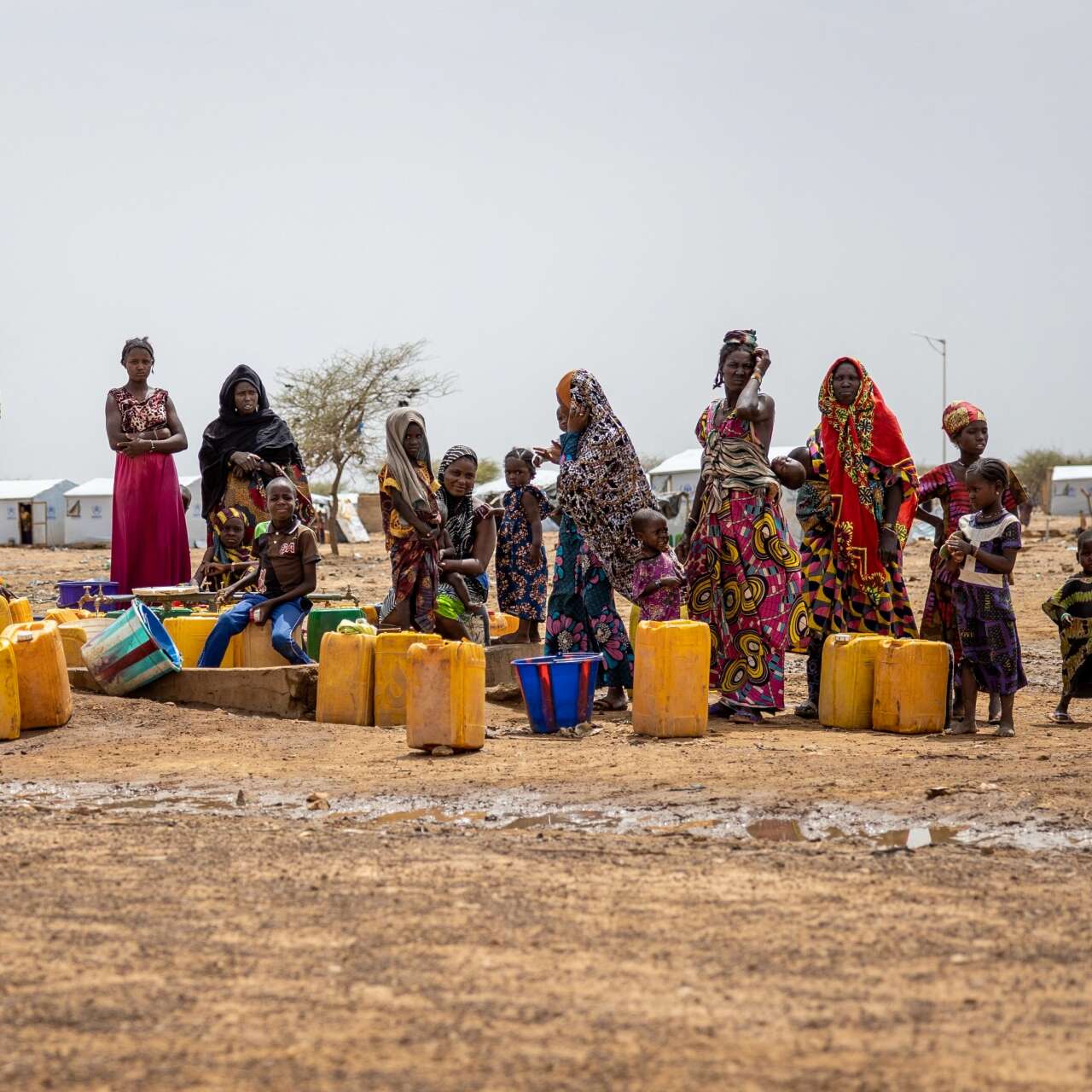 A group of women and children stand near a water collection point in Burkina Faso