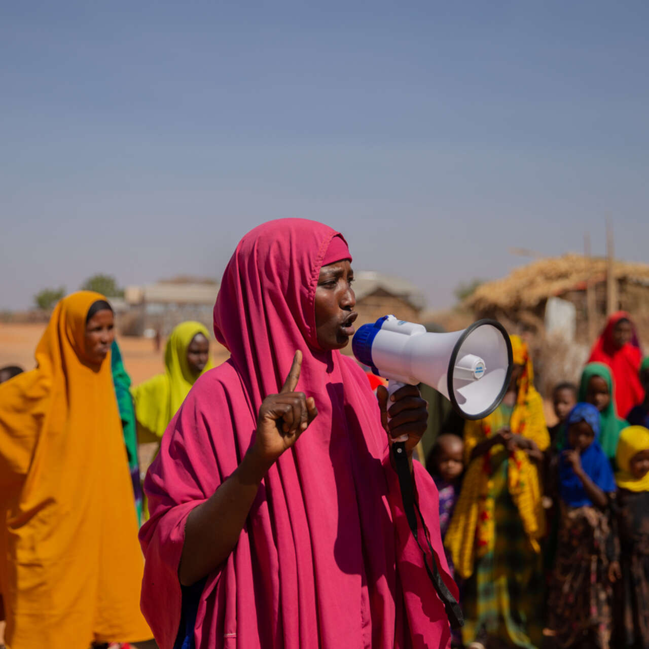 En kvinna i Somalia håller i en megafon och talar till en grupp kvinnor.