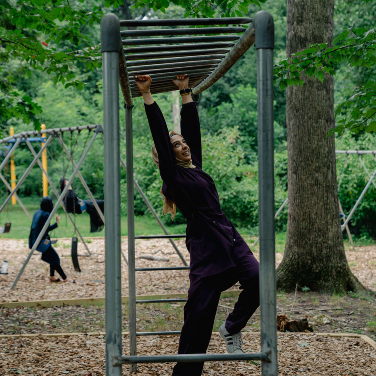 Samira climbs through parallel bars during a break at the IRC’s Summer Academy in Silver Spring, MD.