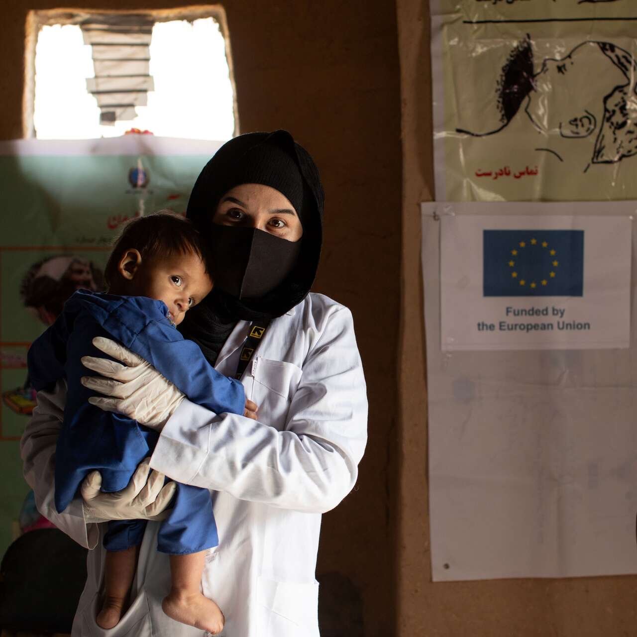  IRC counsellor Ruqia Moqtased comforts Shams Ullah during his malnutrition exam