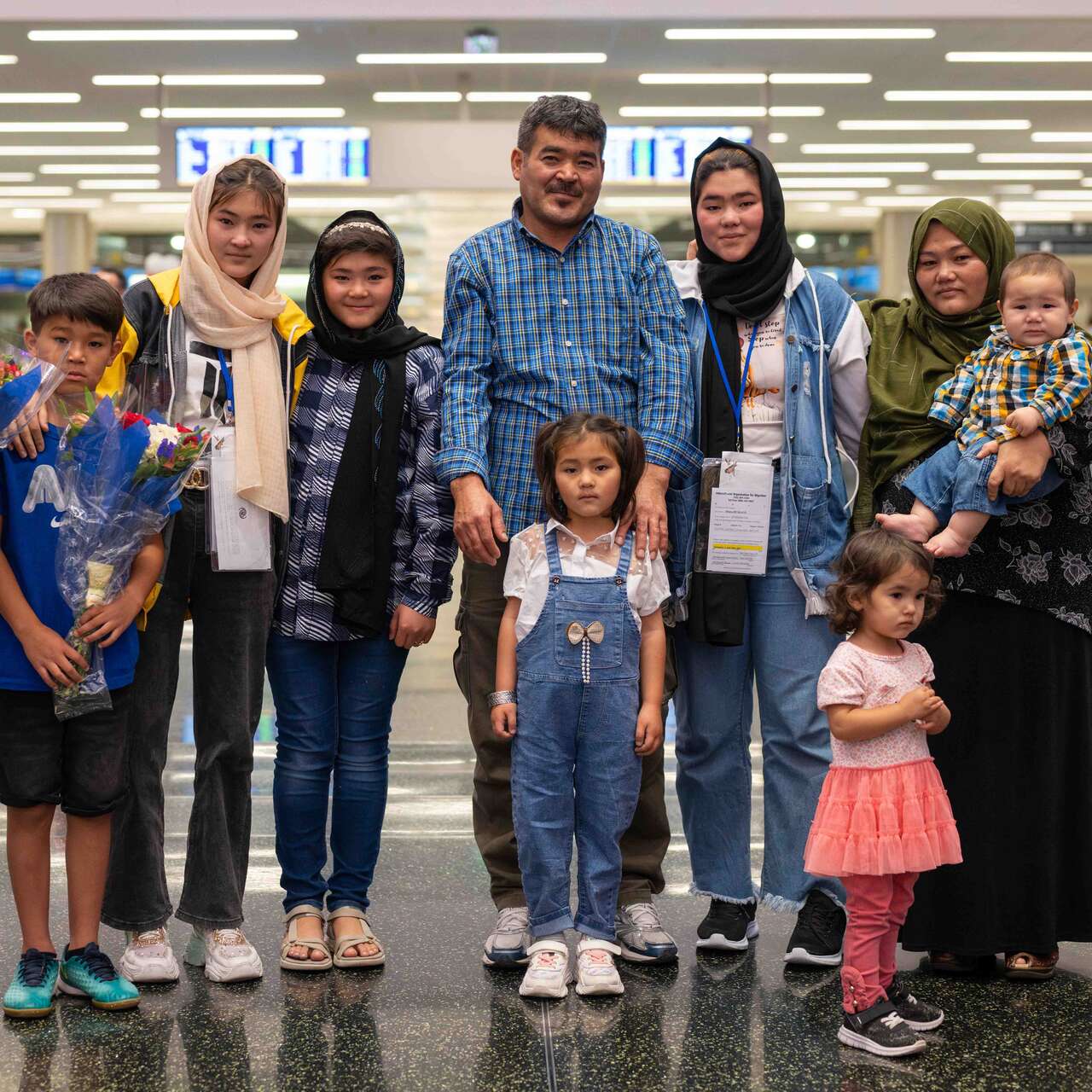 A family poses for a photo together after being reunified at an airport.