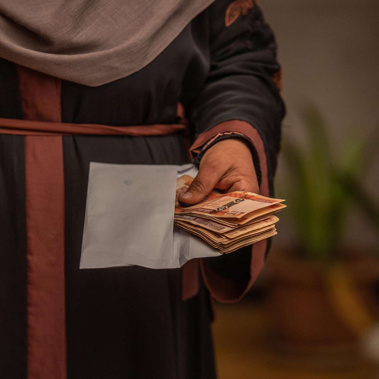 Noor* receives a cash distribution from the International Rescue Committee (IRC).