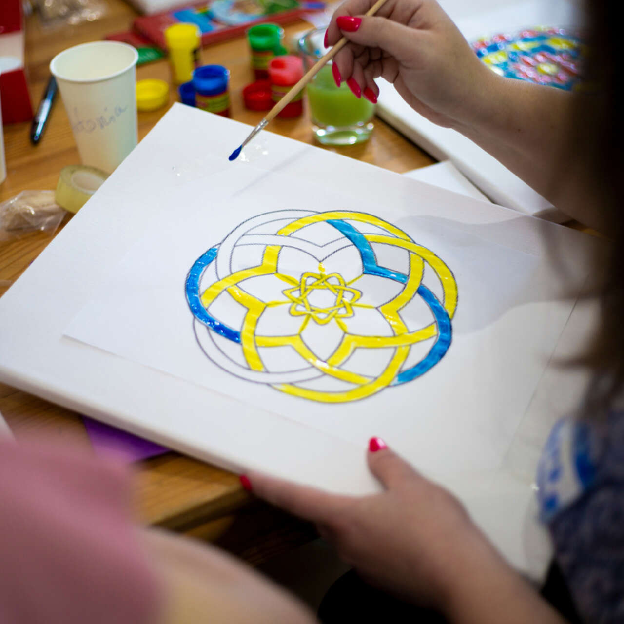 Ein Bild mit einer Person, die ein Mandala ausmalt.
