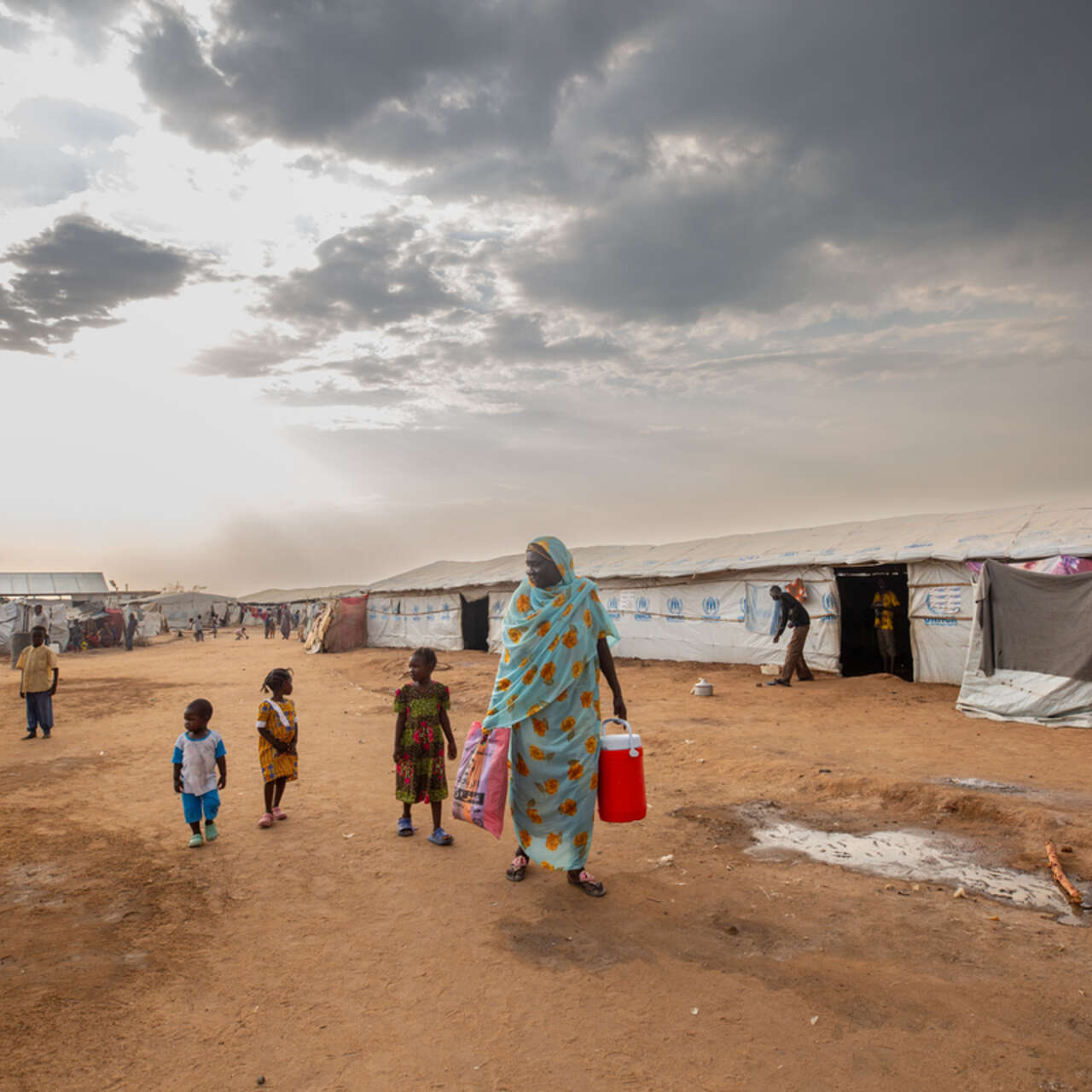 페어루즈가 손자들과 함께 난민캠프 밖에 서 있습니다.