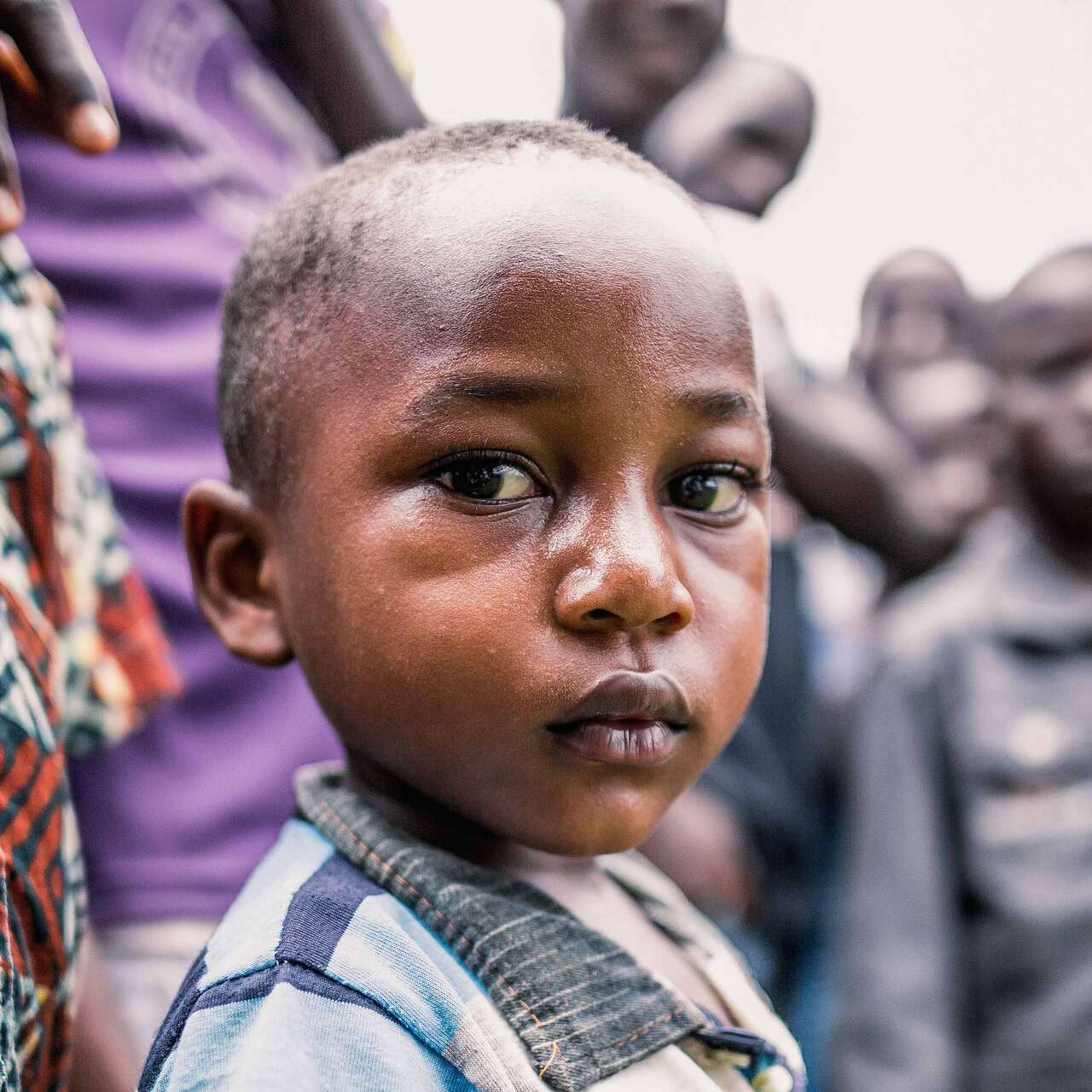 한 어린이가 카메라를 바라보고 서있습니다.