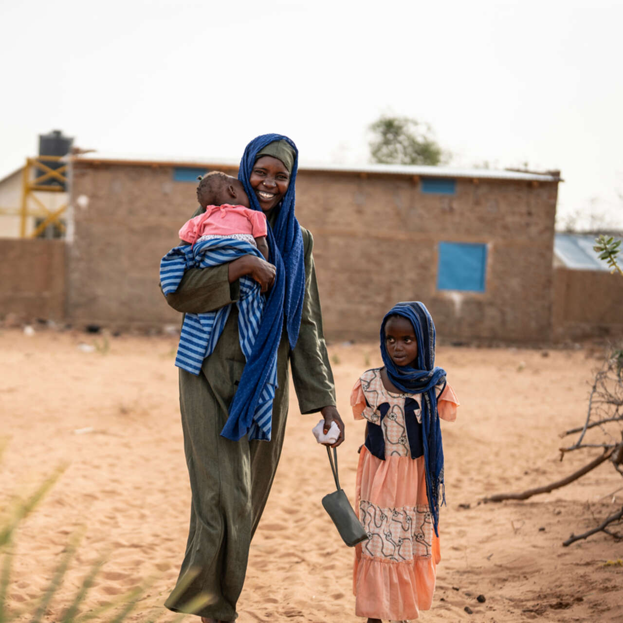 Kvinnor och barn som flytt kriget i Sudan går på en väg efter att ha besökt RESCUE:s hälsocenter i Tchad.