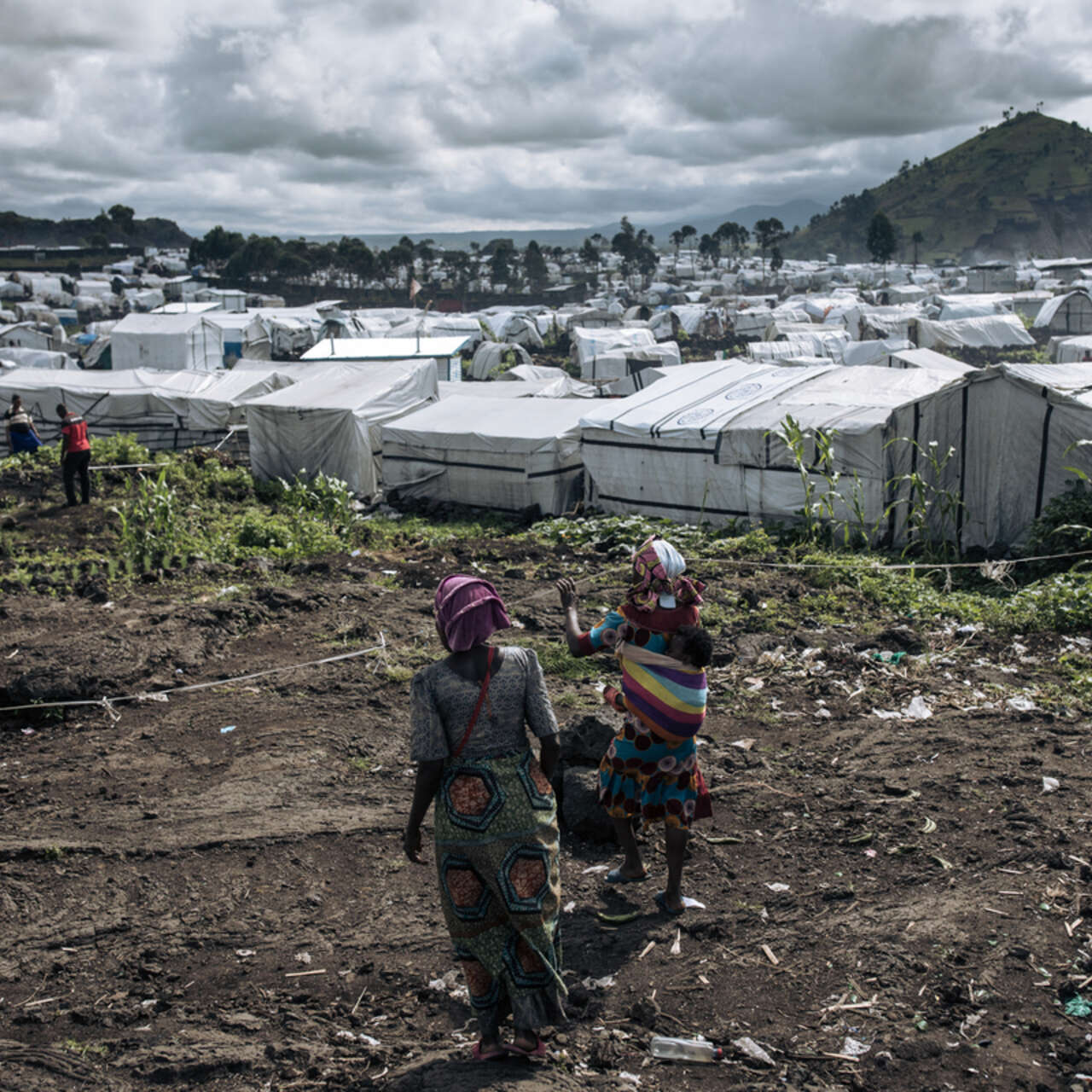 Flyktingläger i östra Kongo-Kinshasa, där konflikten tvingat miljontals människor på flykt. Två kvinnor syns i förgrunden, tält i bakgrunden.