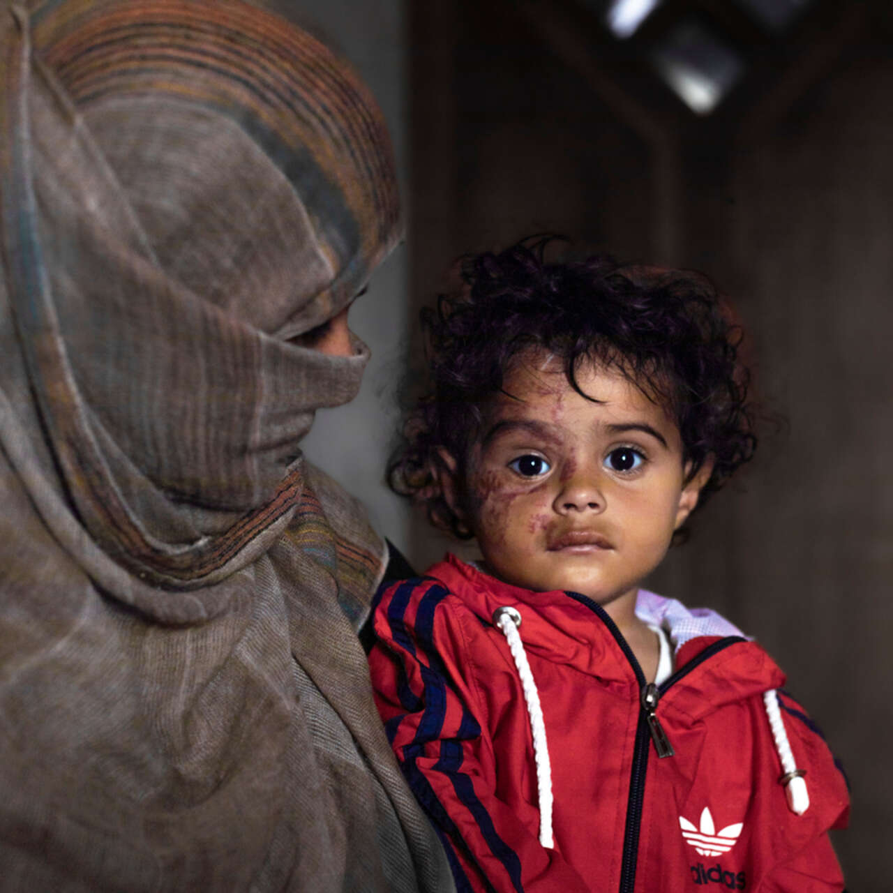 Mamma Rasha sitter med hennes tvååriga dotter Jana i knät.