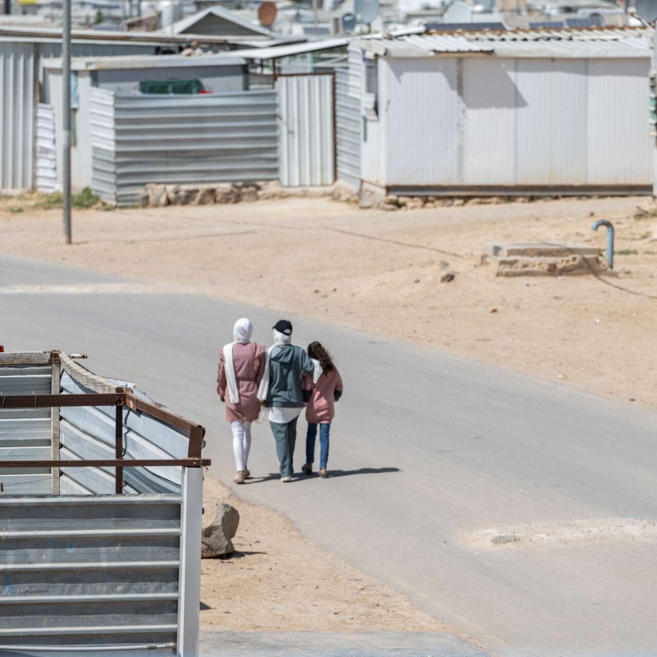 Three women walk through the Za'atari refugee camp.