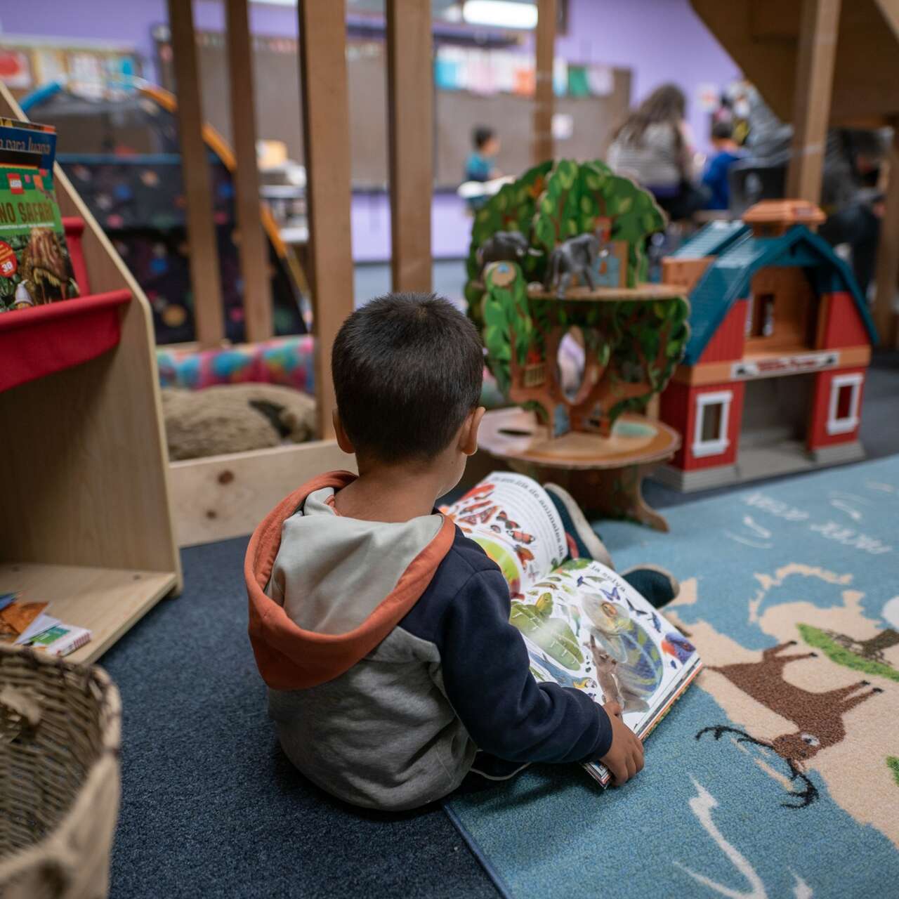 A young boy reads a book by himself at the IRC's Welcome Center in Phoenix, Arizona.