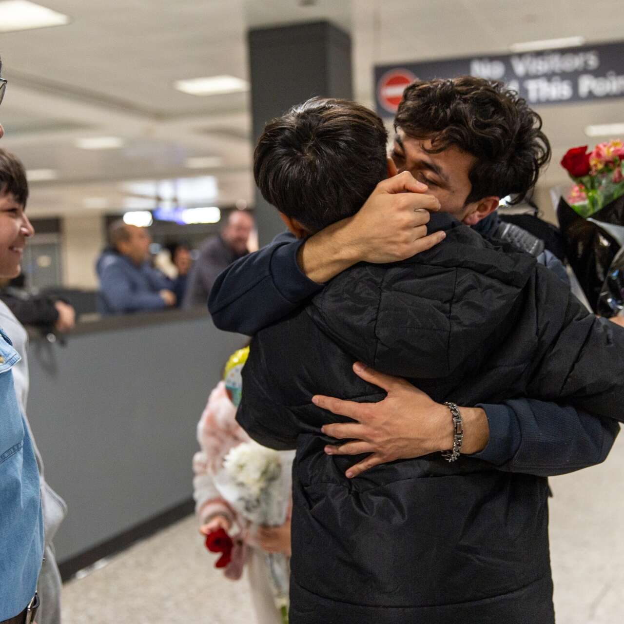 Two siblings embrace after being reunited in the U.S.