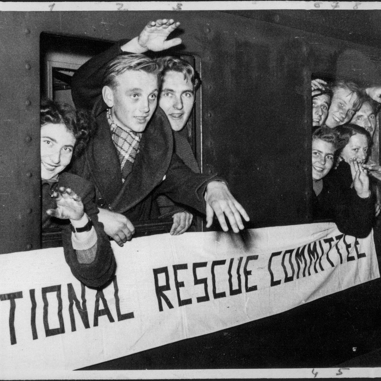 People wave from a train window