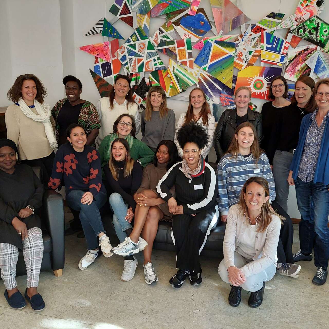 Gruppenfoto vor bunter Wandmalerei in kreativem, modernem Raum