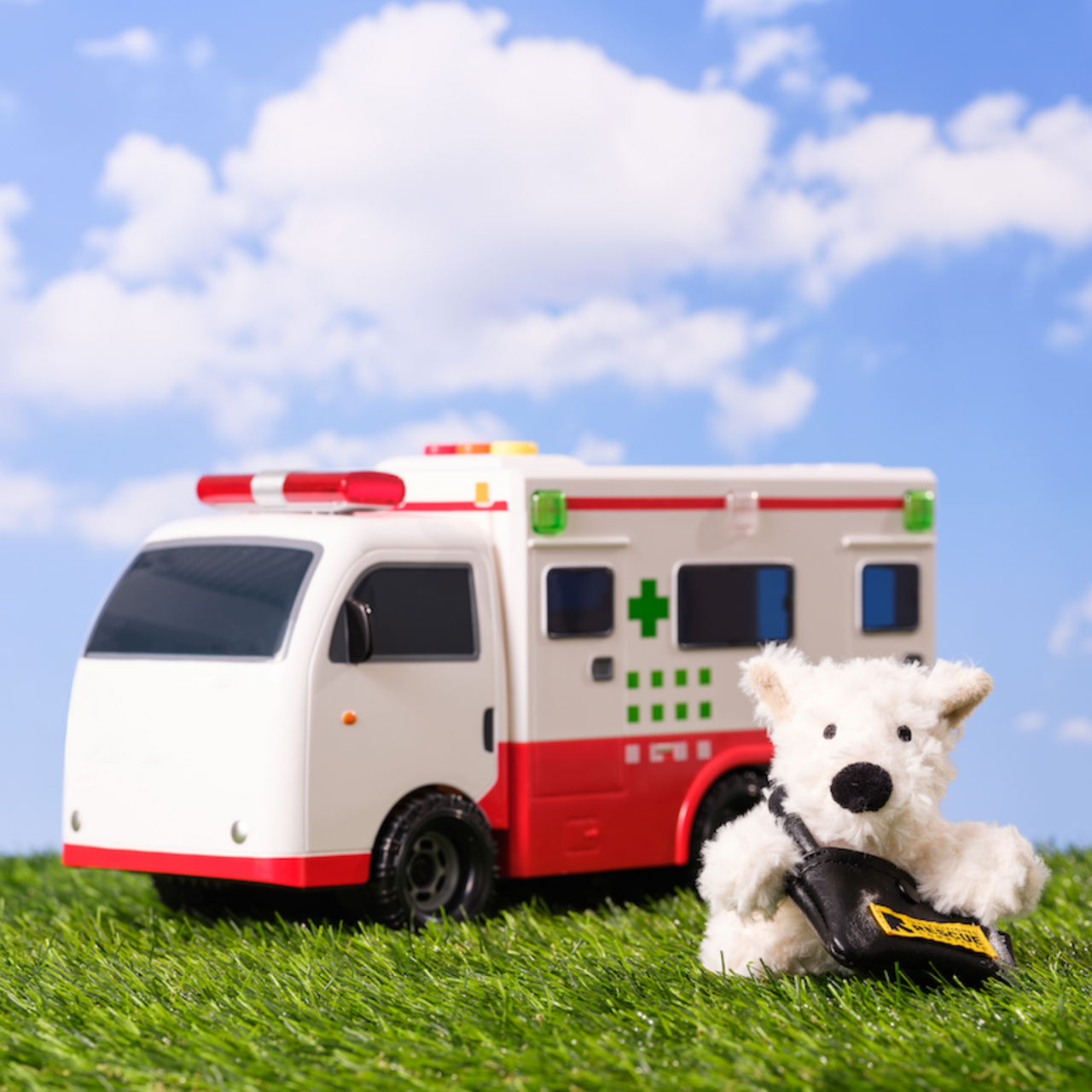 구조댕 인형이 모형 앰블란스 앞에 서있습니다.