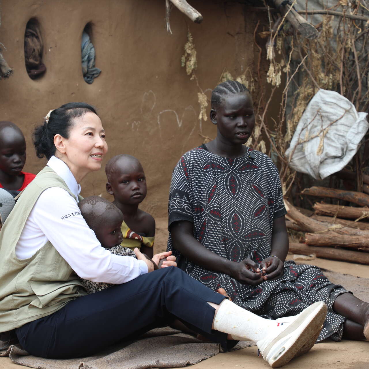 국제구조위원회 오민애 홍보대사가 케냐 카쿠마 캠프의 한 고객의 집에 방문하여 이야기를 나누고 있습니다.