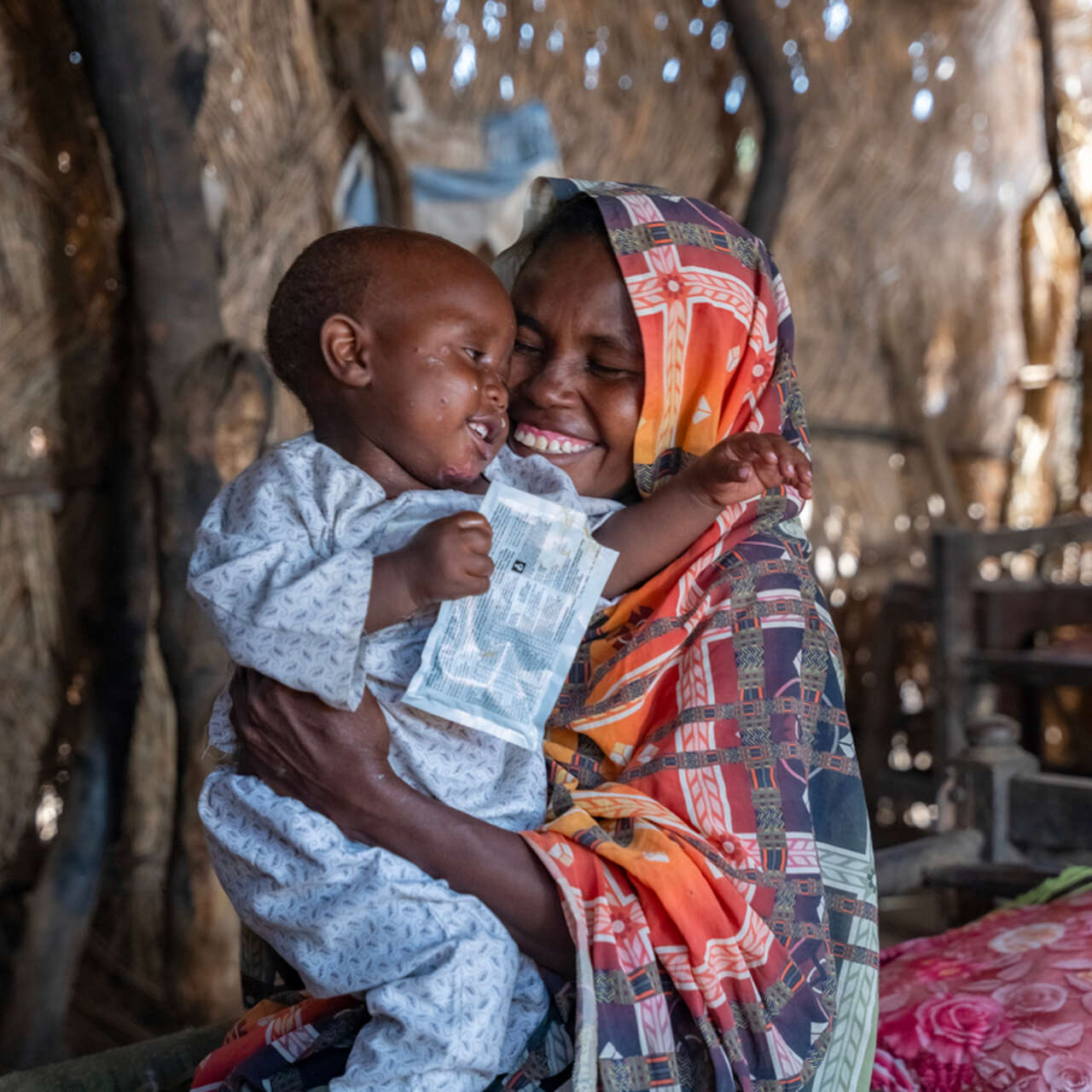 Anwar’s mother, Shama, plays with him inside their home in Al-Azaza.