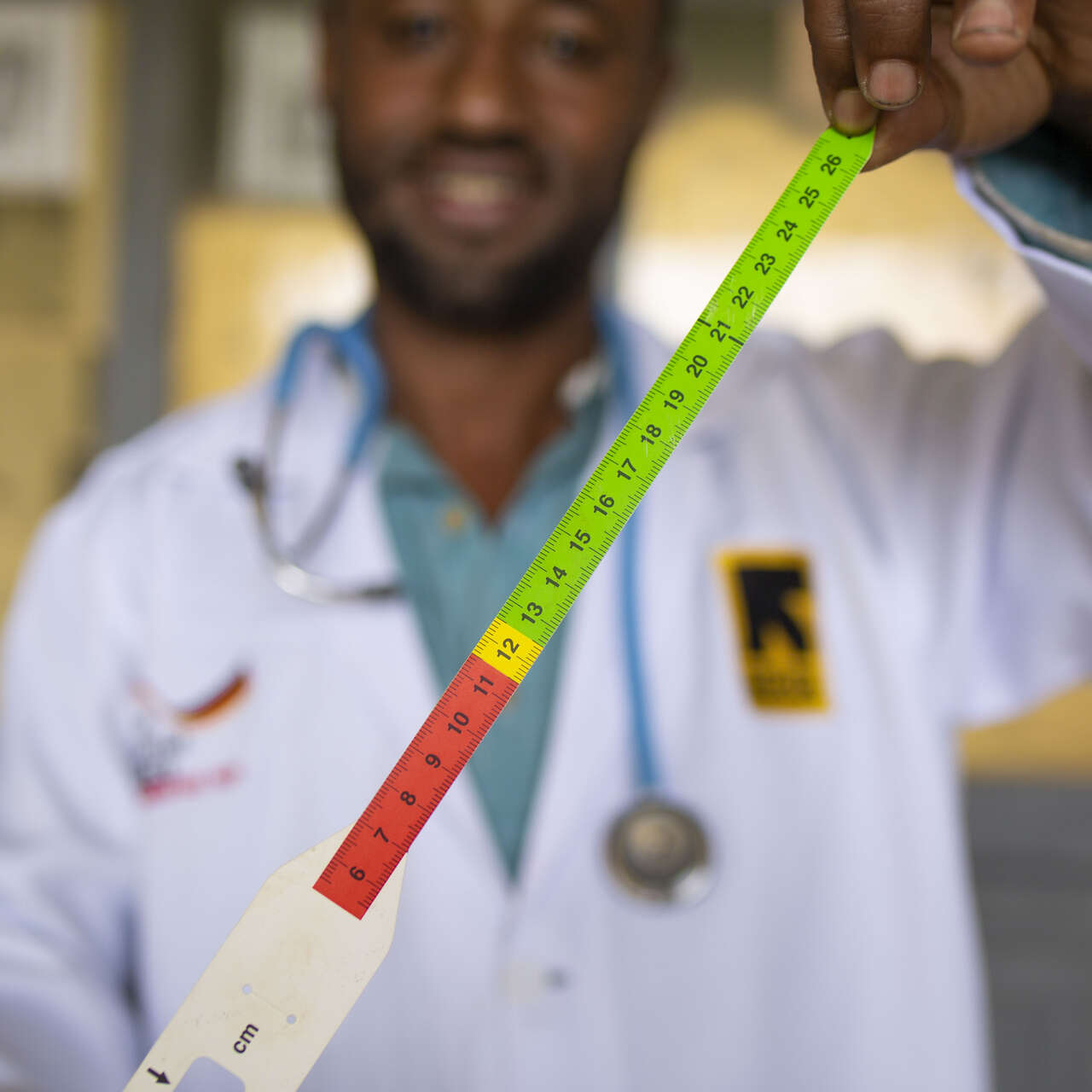 Ernährungsexperte Abdurahman Gidi zeigt ein MUAC-Band zum Messen des Oberarmumfangs von Kindern.