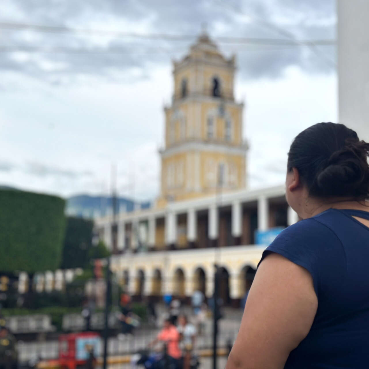 Woman looking at a building, we see her from the back.