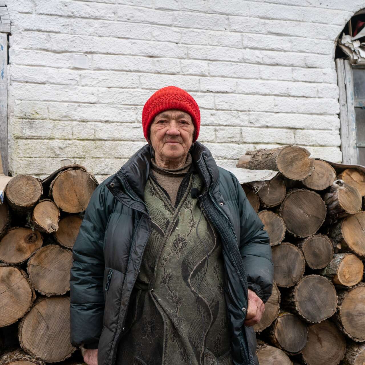 Woman standing in front of fuel logs wearing winter clothes
