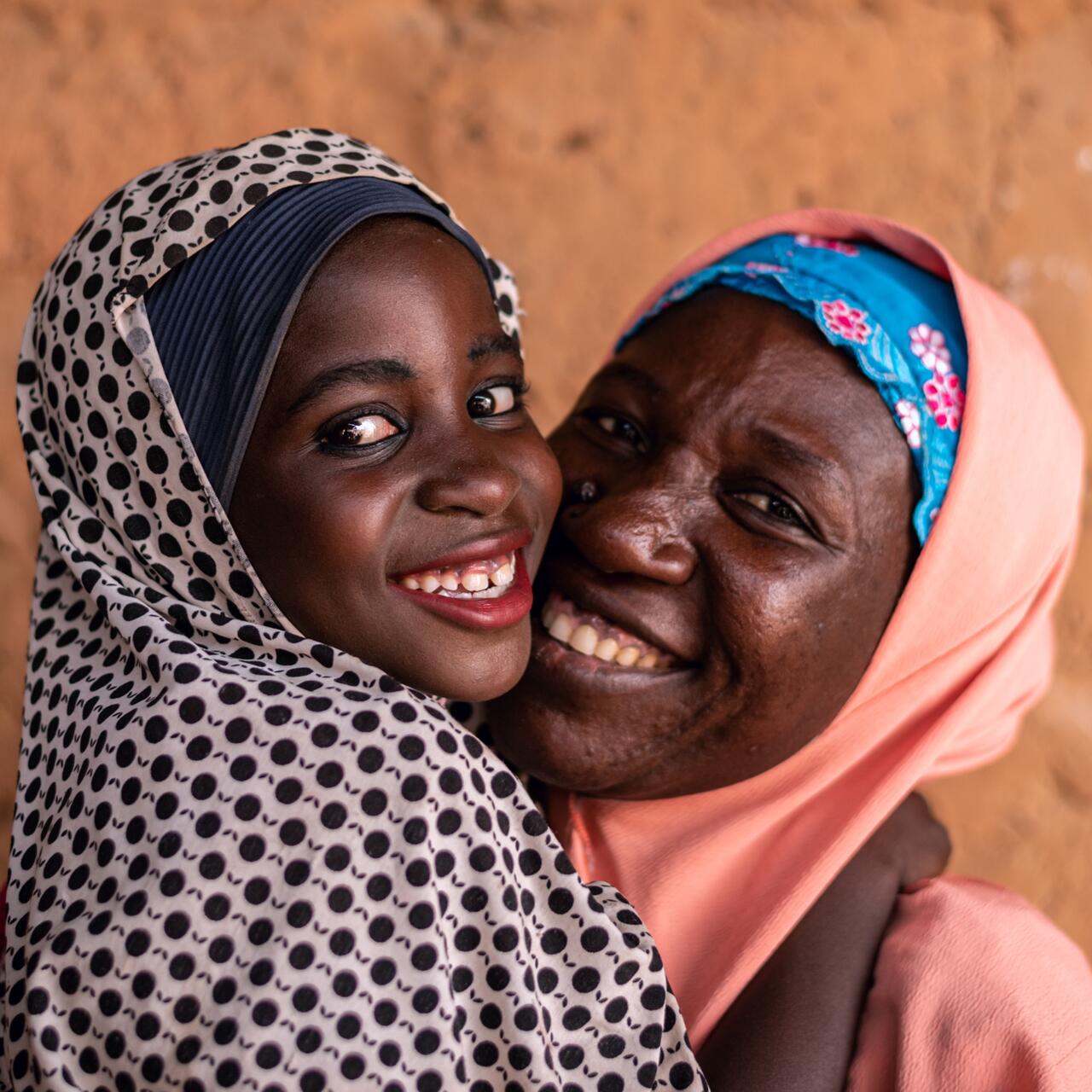 Fatima, age 8, hugs her mother before going to school.