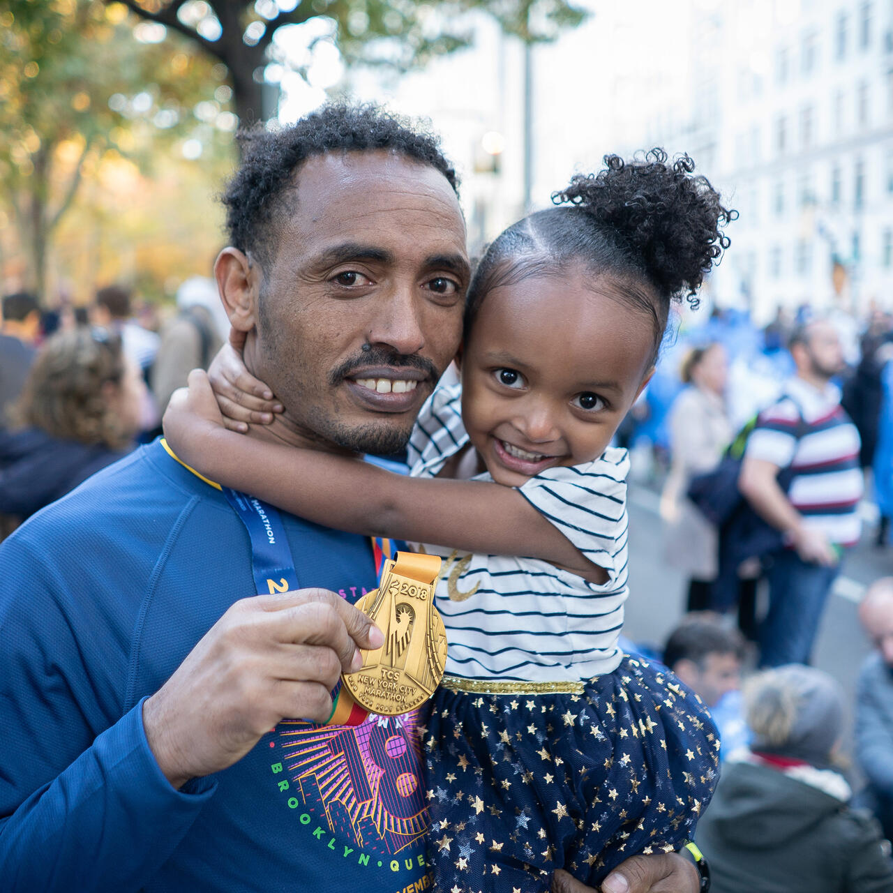 Ethiopian runner Tolassa Elemaa holds his daughter after completing the New York City Marathon on Nov. 7, 2018