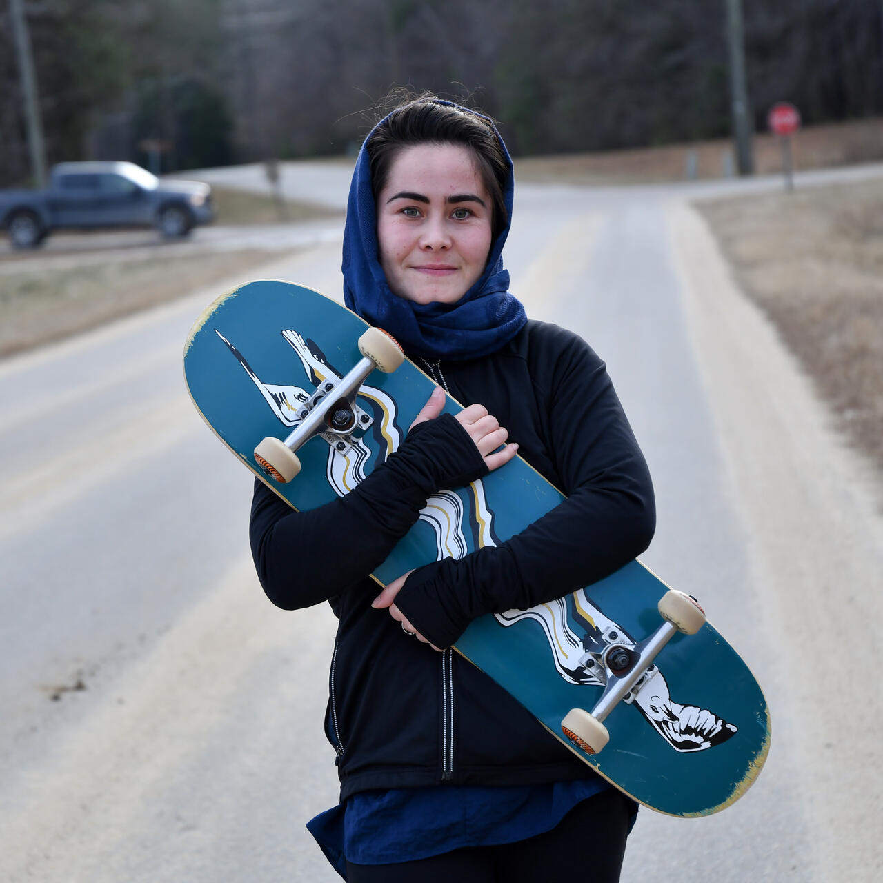 Belqisa holds her skateboard