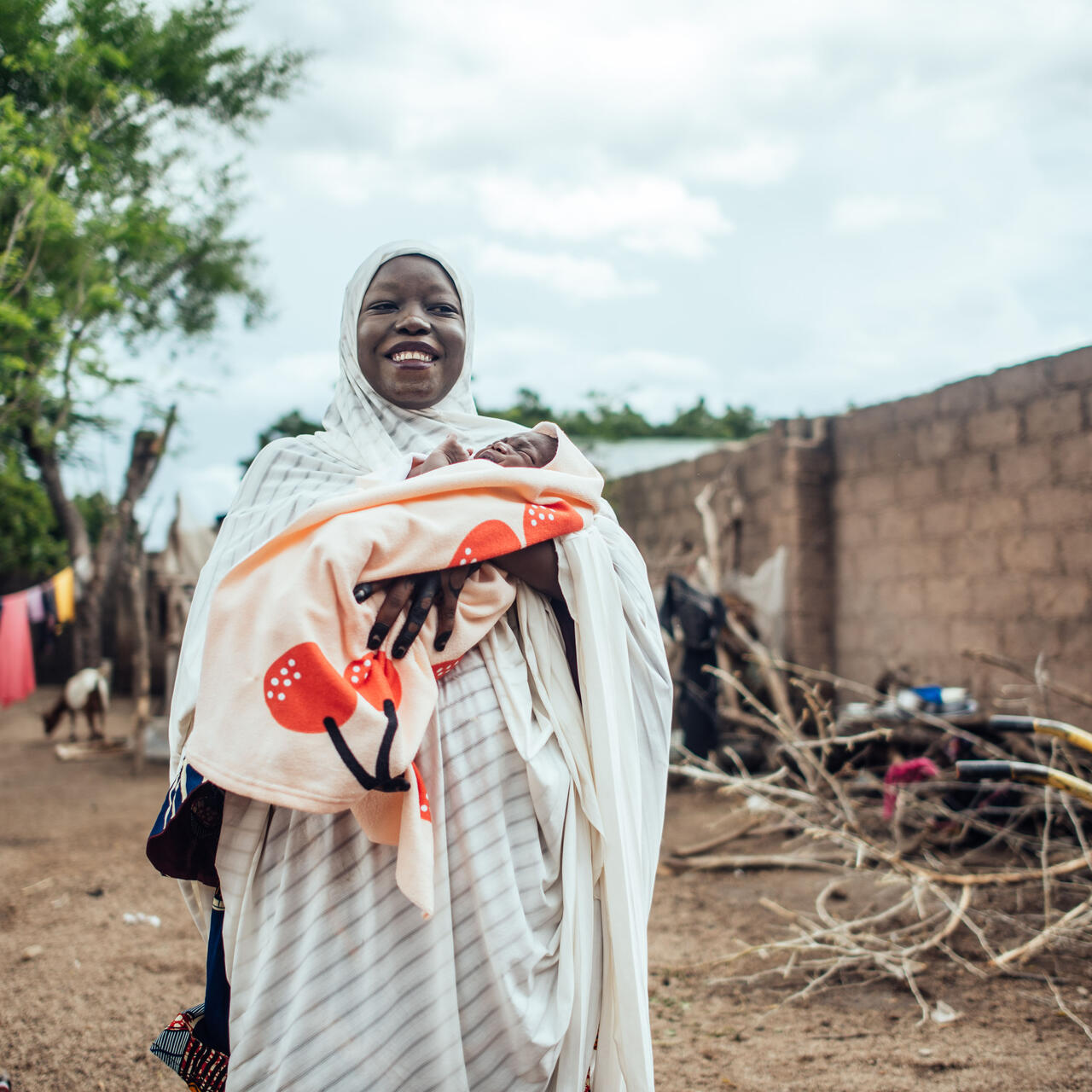 IRC client Hussiena Ibrahim smiles holding her 7 day old baby.