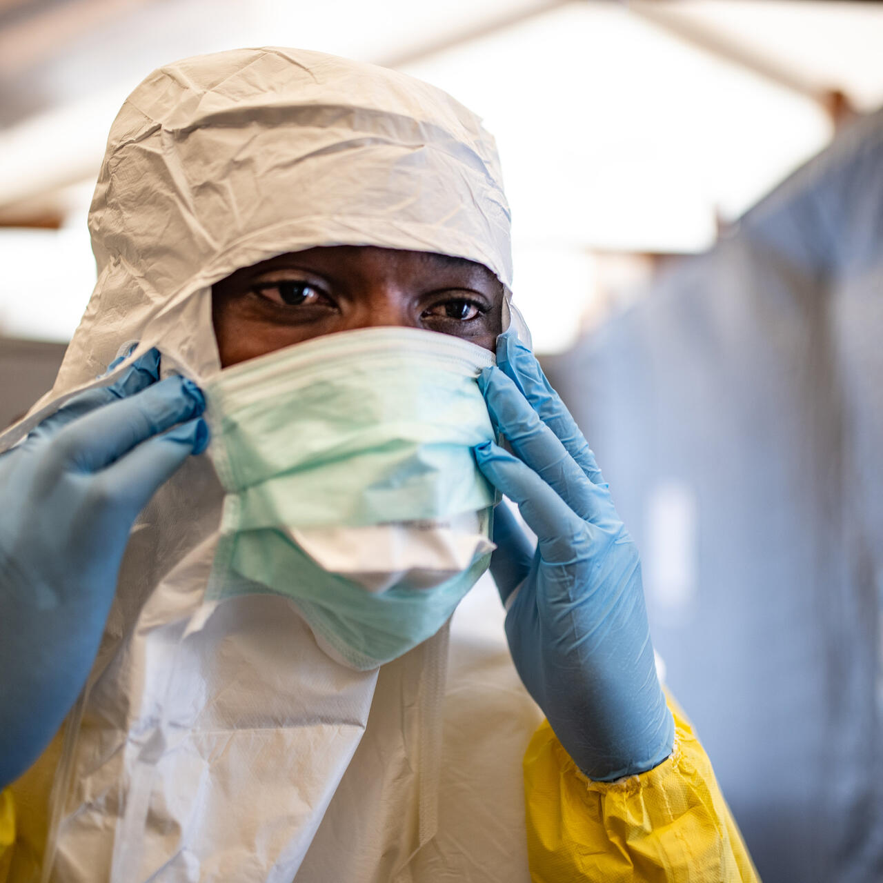 A health worker in the Democratic Republic of Congo puts on a face mask along with other protective equipment to care for patients in an area affected by a deadly Ebola outbreak