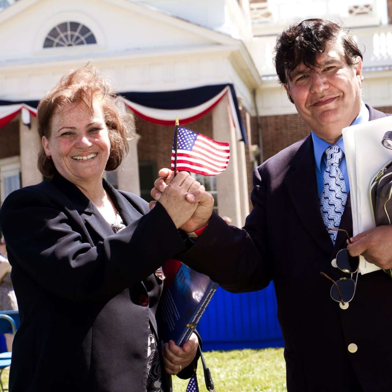 A refugee couple hold an American flag at their naturalization ceremony in Charlottesville, VA/ 