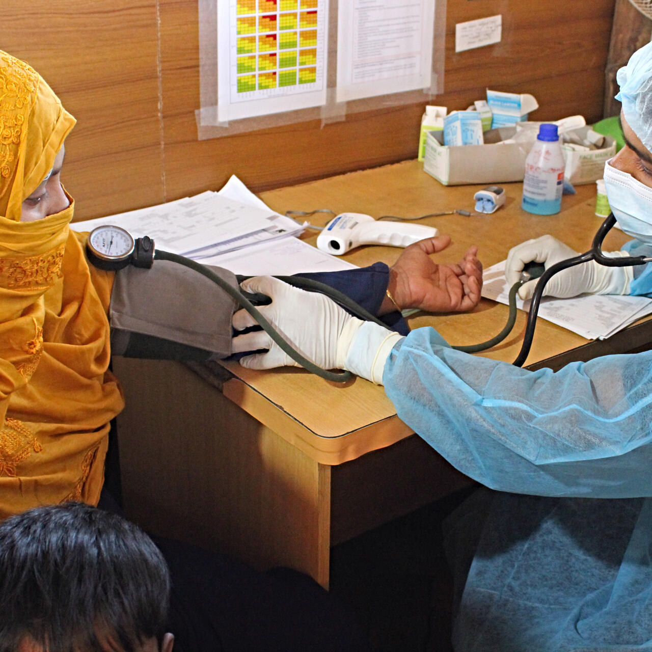 A paramedic takes the blood pressure reading of a young woman in Bangladesh